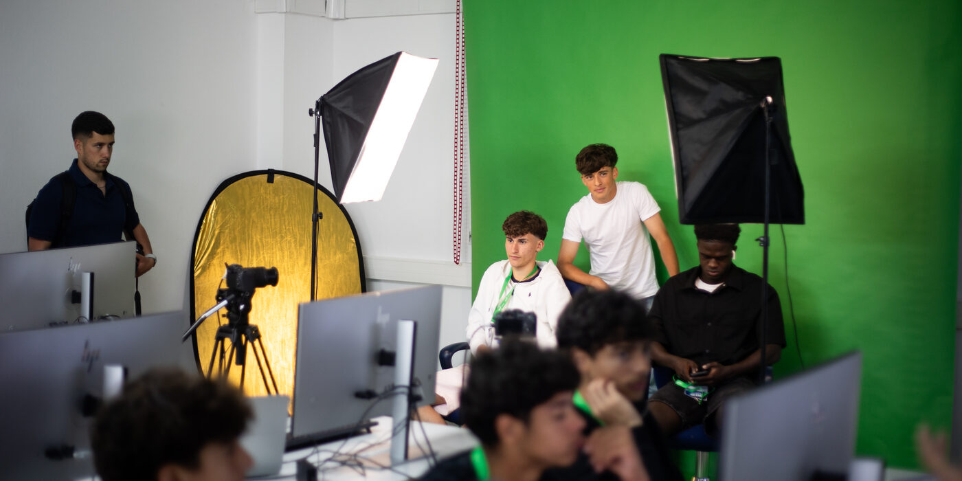 Estúdio multimédia com alunos e equipamentos de produção audiovisual